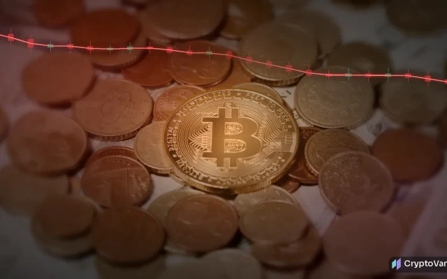 Bitcoin worst October illustration: a gold bitcoin coin on a pile of coins under red light with a falling candlestick chart