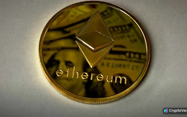 Close-up of a gold coin stamped with the ethereum symbol on a pale background