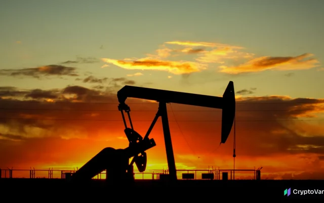 Silhouette of an oil pump jack against an orange sunset sky
