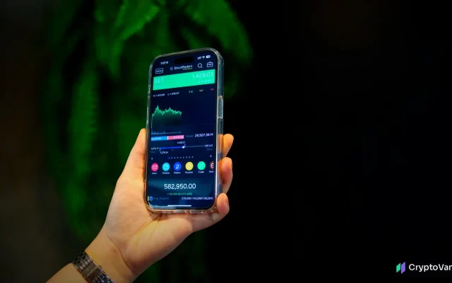 Hand holding a smartphone with a trading app, illustrating a Robinhood stock token