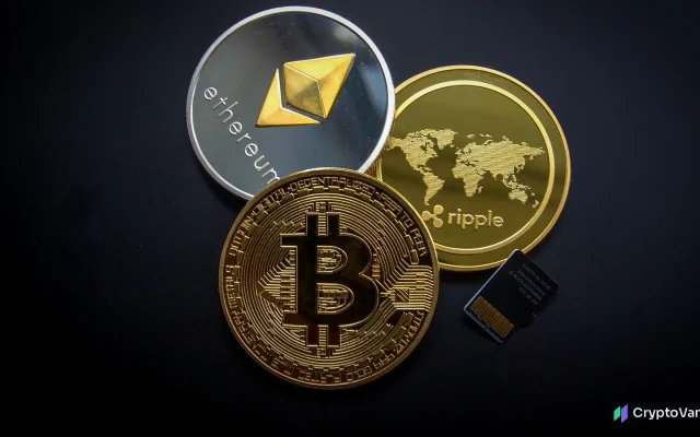 Physical bitcoin, ethereum and ripple-branded coins lying together on a dark surface